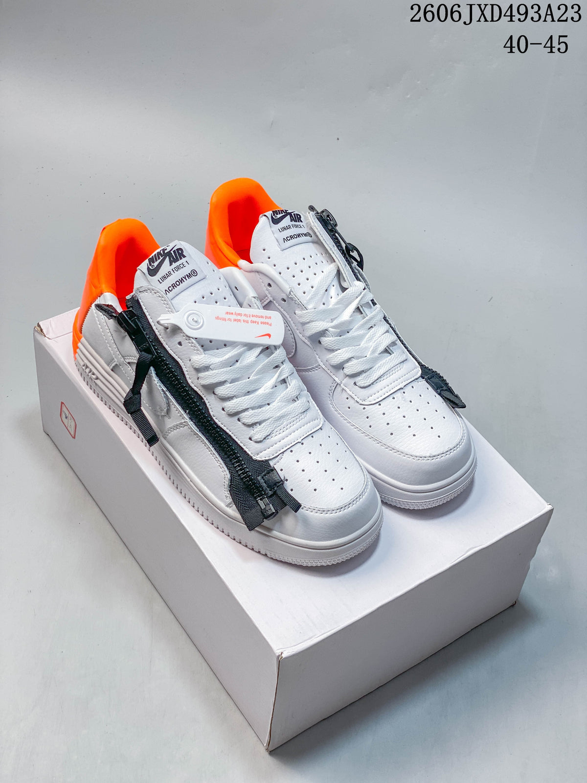 White low-top sneakers with dark zipper details and bright orange lining