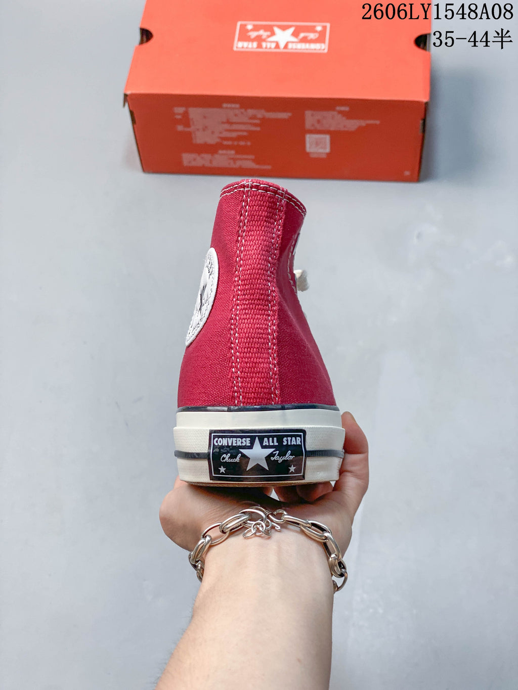 Rear view of a red Converse high-top sneaker with a heel label and off-white sole.