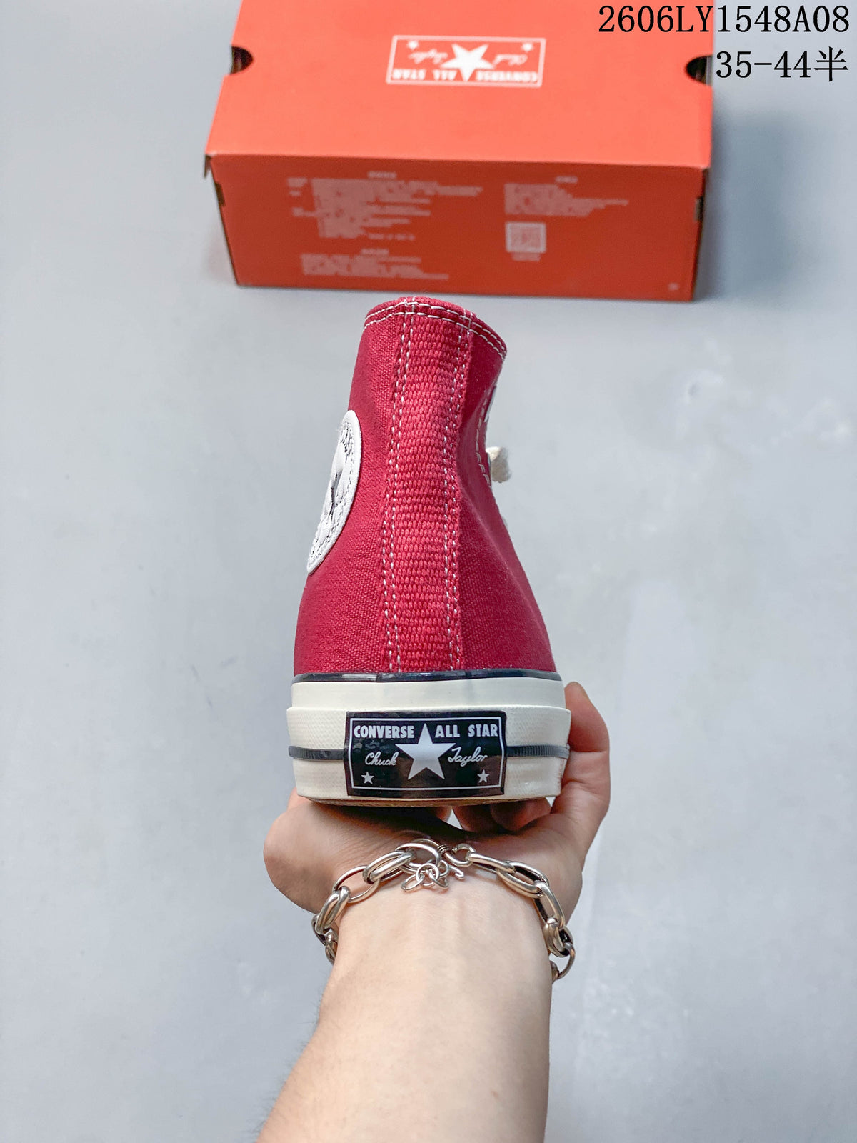 Rear view of a red Converse high-top sneaker with a heel label and off-white sole.