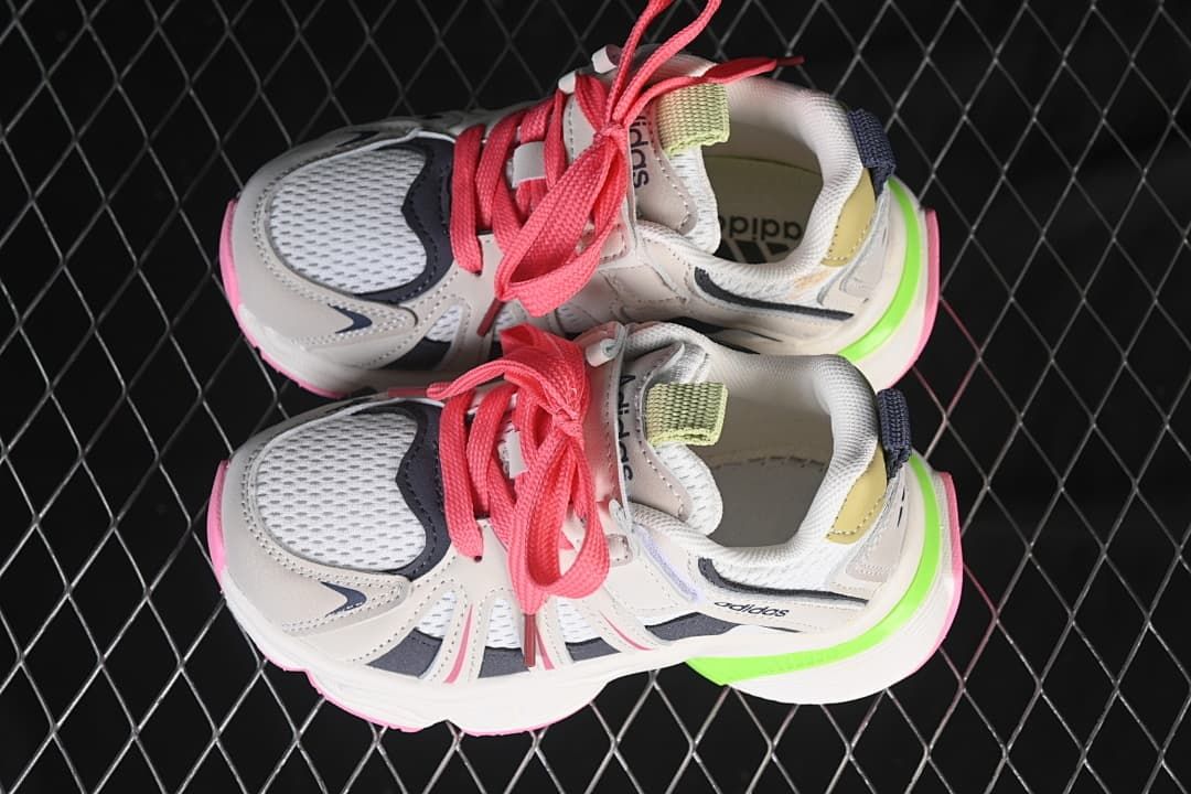 Pair of gray and white kids’ sneakers with pink laces and bright accent details.