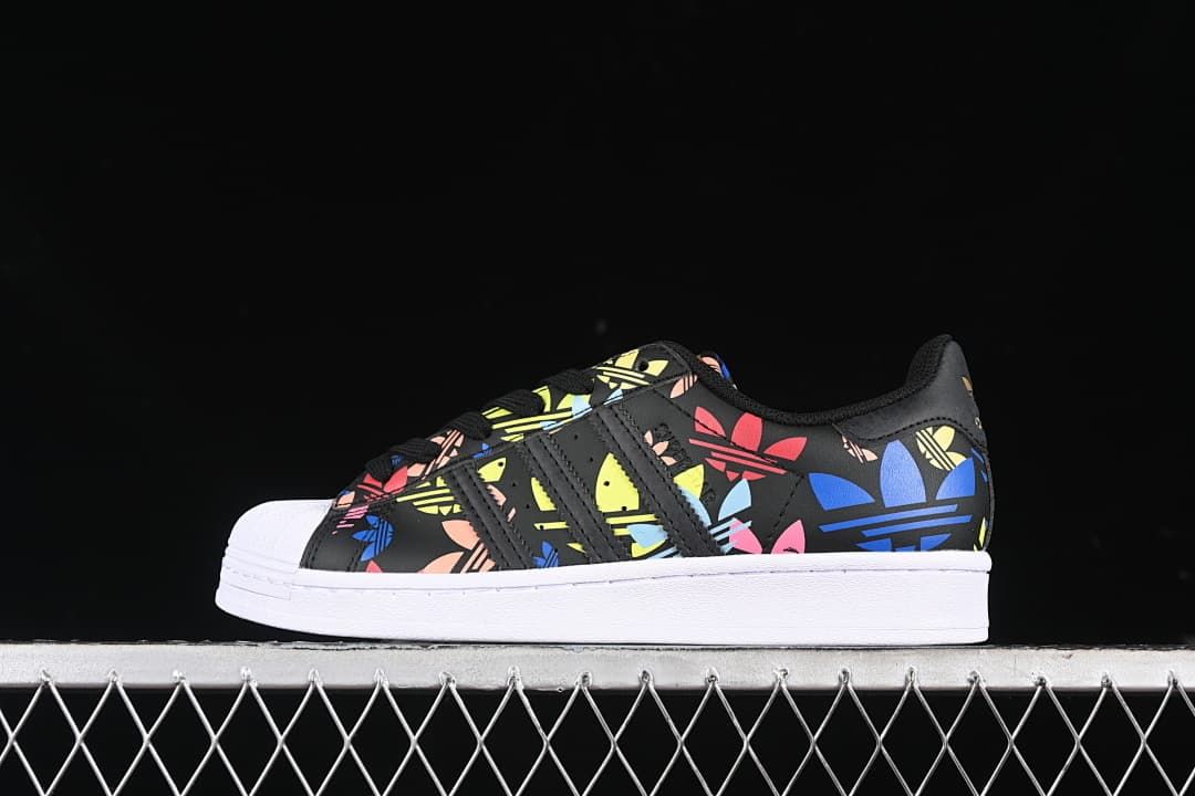 Side view of a black adidas Superstar with colorful graphics, shell toe, and white sole
