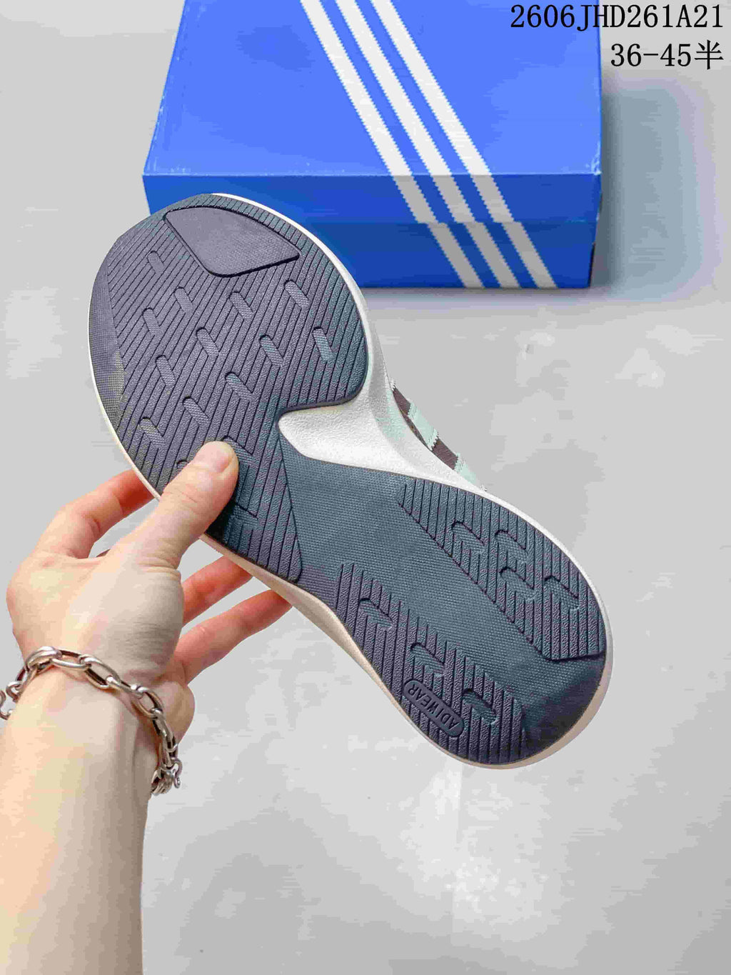 Underside of the sneaker showing a dark patterned outsole
