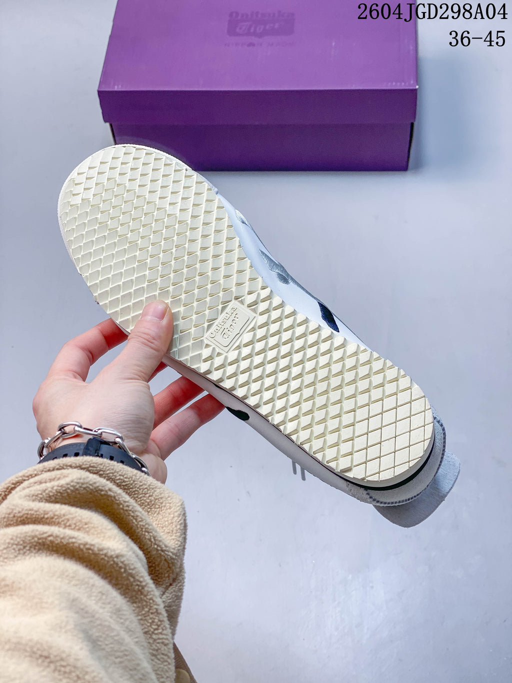 Close-up of the cream-colored patterned outsole on a white sneaker.