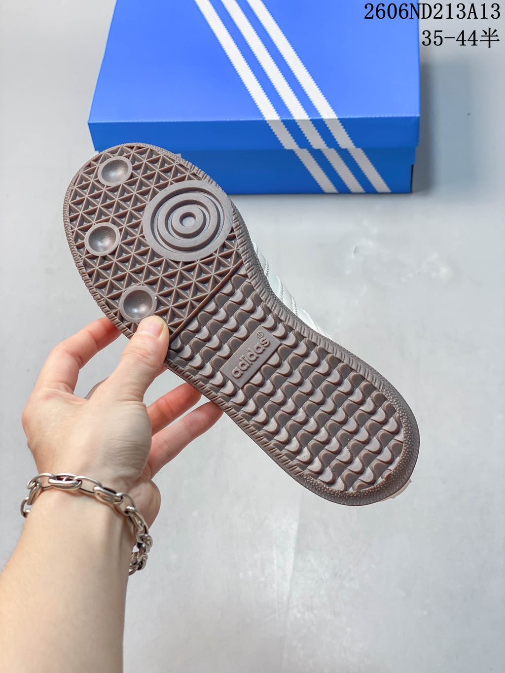 Close-up of the textured grey-brown outsole on an adidas Samba OG sneaker