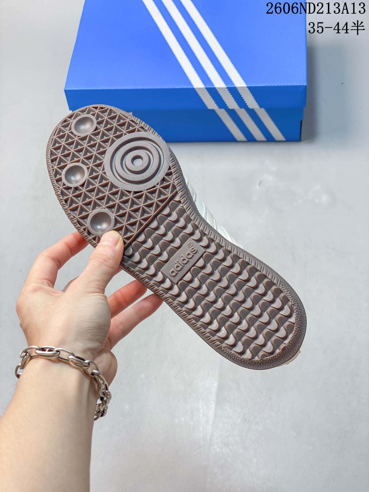 Close-up of the textured grey-brown outsole on an adidas Samba OG sneaker