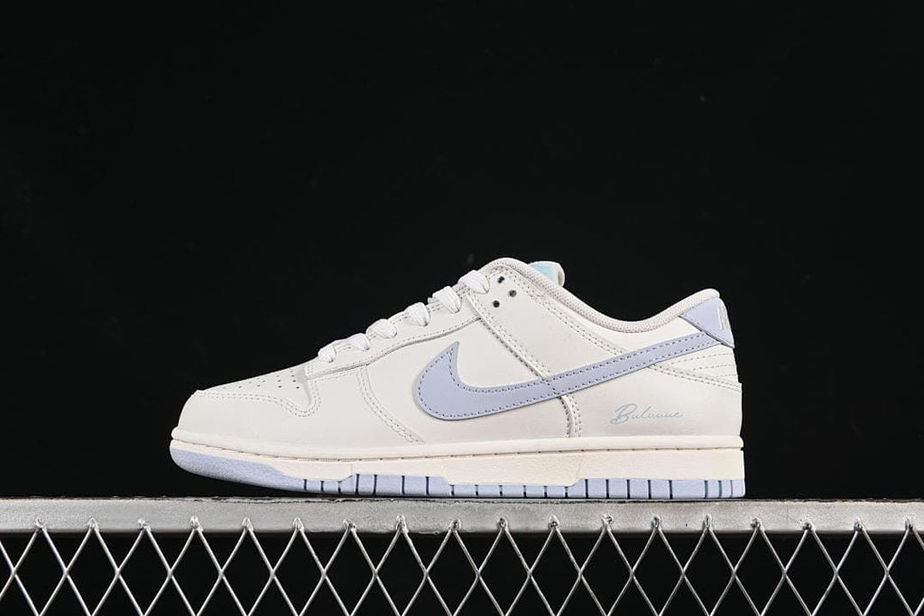 Side profile of a white Nike SB Dunk Low with a light blue Swoosh