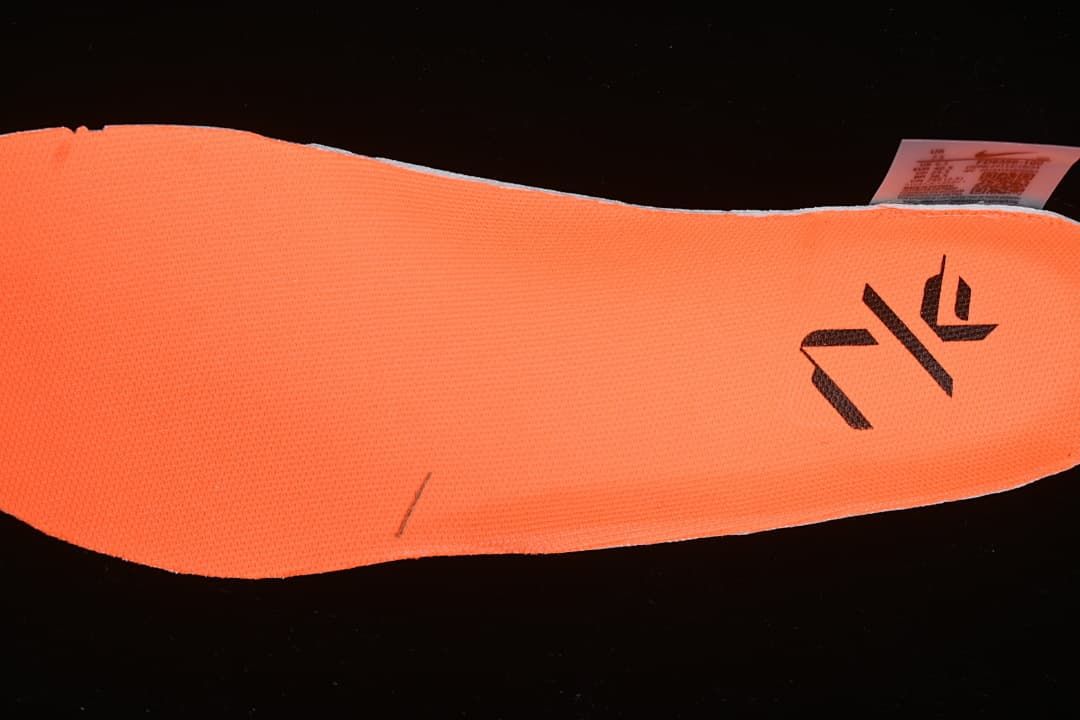 Bright orange shoe insole with printed branding