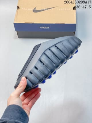 Side view of the dark gray-black slide showing the textured upper and rounded outsole profile.