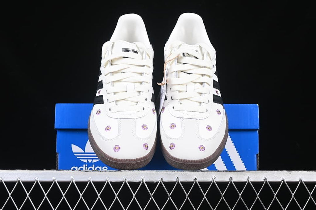 Front view of the floral sneakers displayed on a blue adidas box