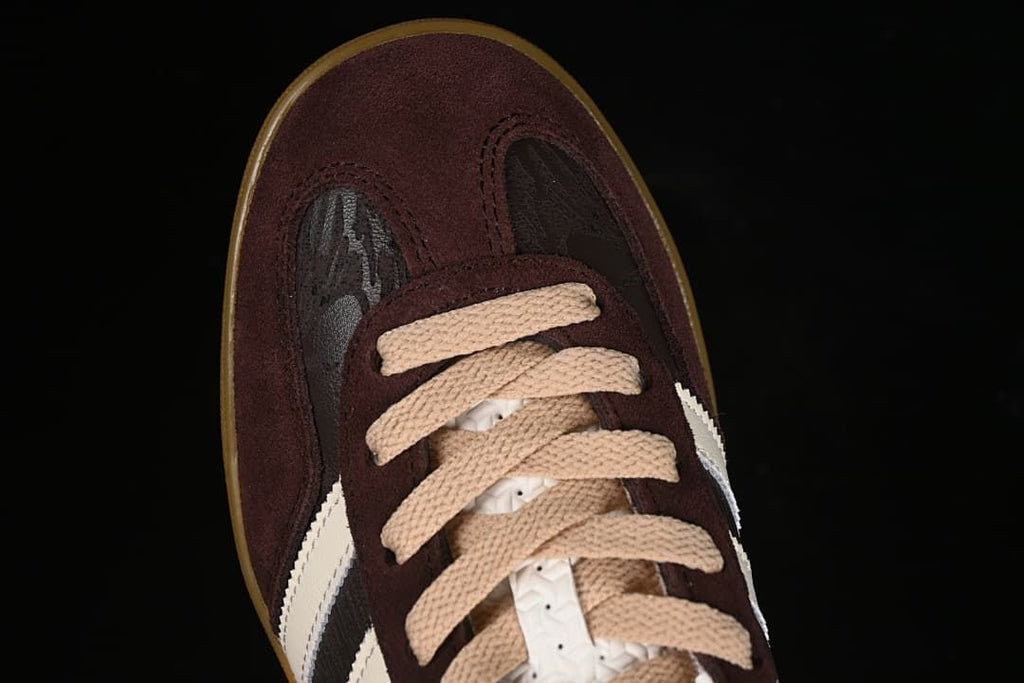 Top-down close-up of the burgundy toe panel and beige laces.