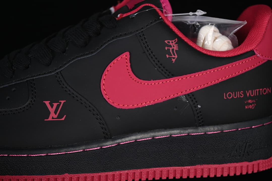 Side close-up of black sneaker with red panels and decorative graphics
