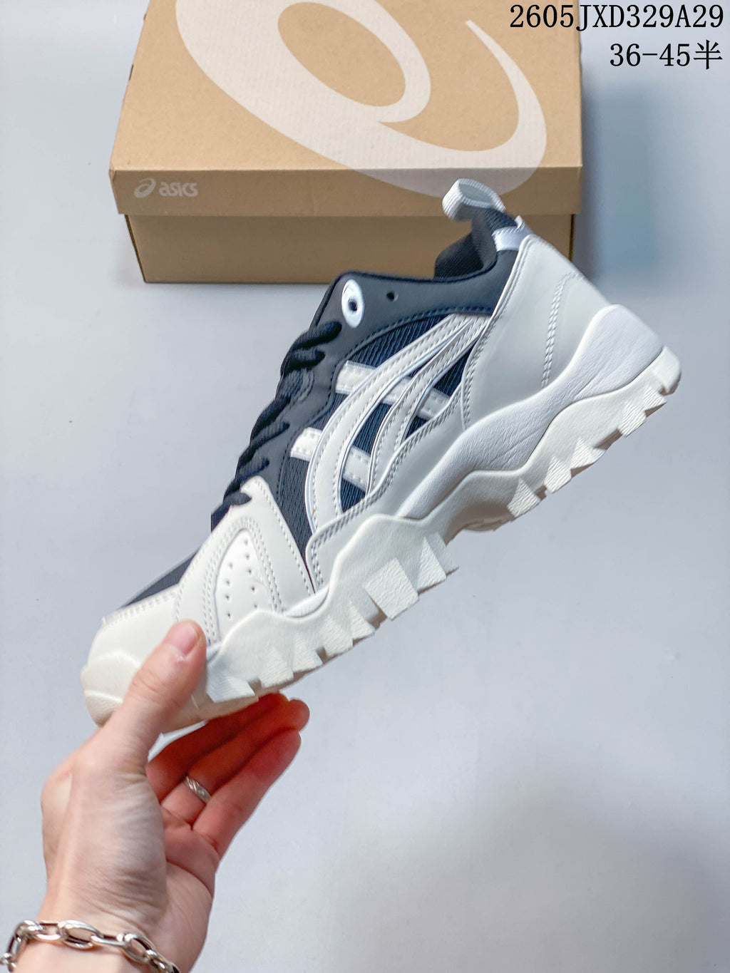 Side profile showing silver-toned stripes, navy panels and chunky outsole.