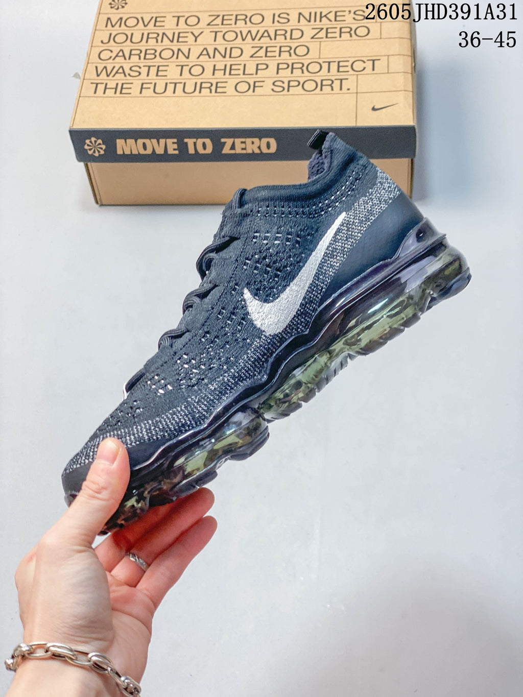 Side profile of a dark navy Nike Air VaporMax Flyknit shoe with a light Swoosh