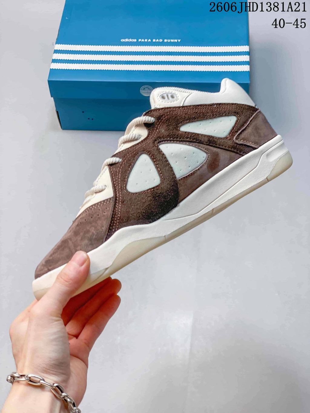 Side view of the low-cut shoe with brown and taupe panels, off-white inserts, and a light-colored sole; image overlay shows 40–45.