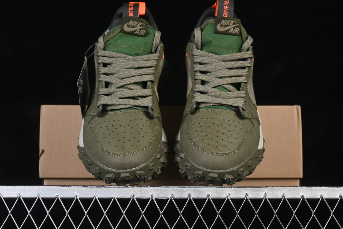 Front view of olive Air Jordan 1 Low Element sneakers with gray laces, green tongues, and orange pull tabs.