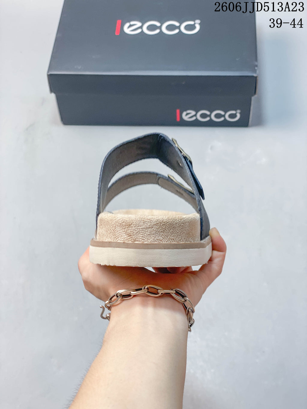 Rear view of a slide sandal showing the heel strap and light-colored sole