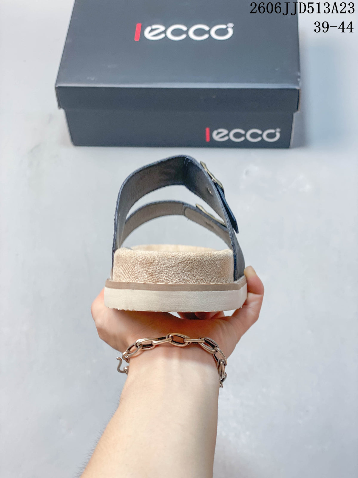 Rear view of a slide sandal showing the heel strap and light-colored sole