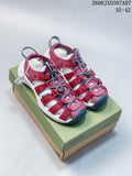 Pair of berry KEEN Newport H2 sandals on a shoebox, showing the front and upper.