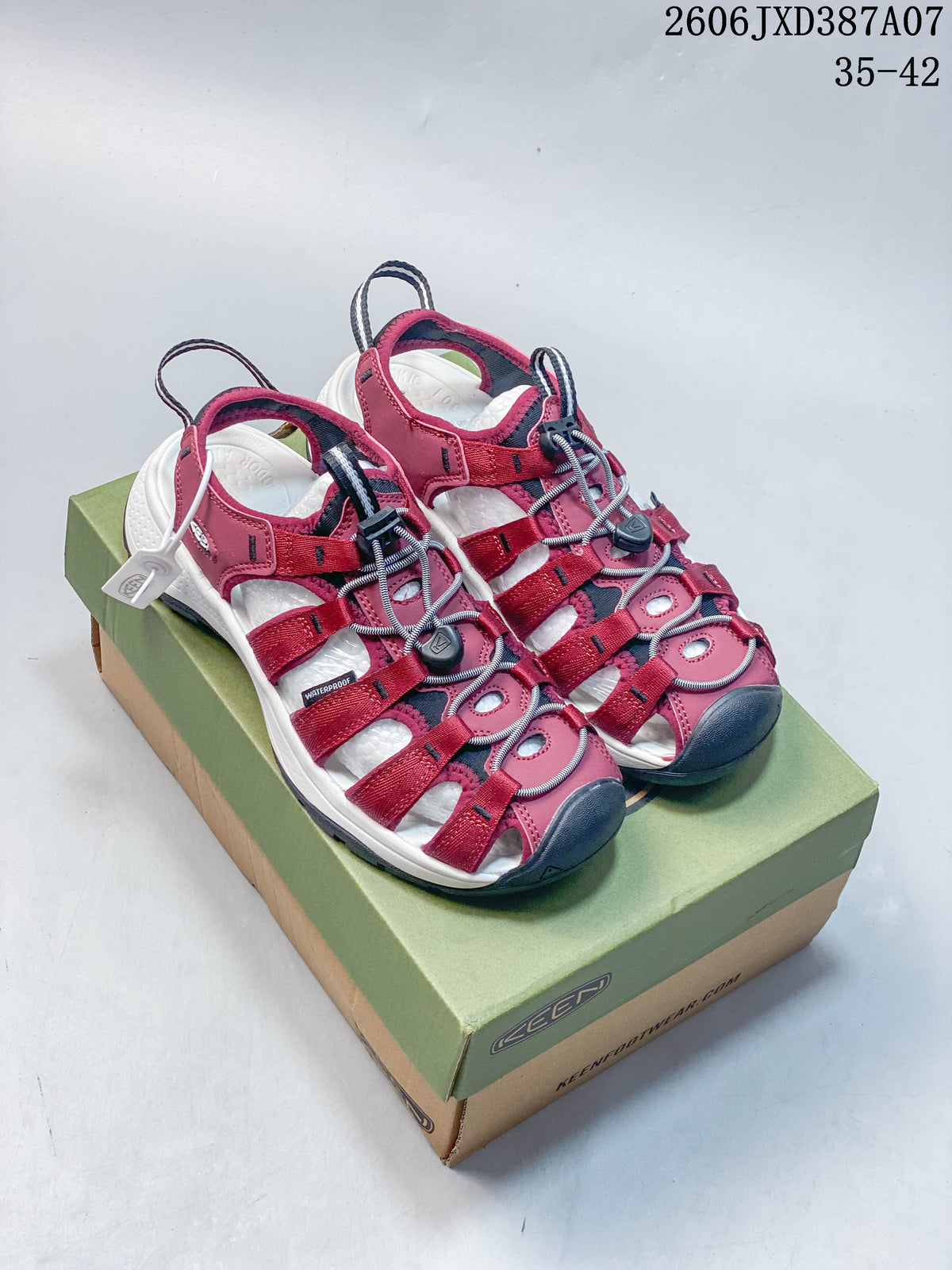 Pair of berry KEEN Newport H2 sandals on a shoebox, showing the front and upper.