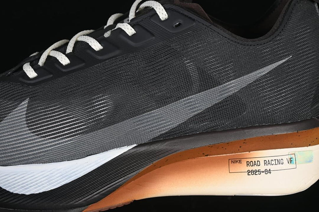 Close side detail of the dark upper, Swoosh, and copper-toned midsole accent.