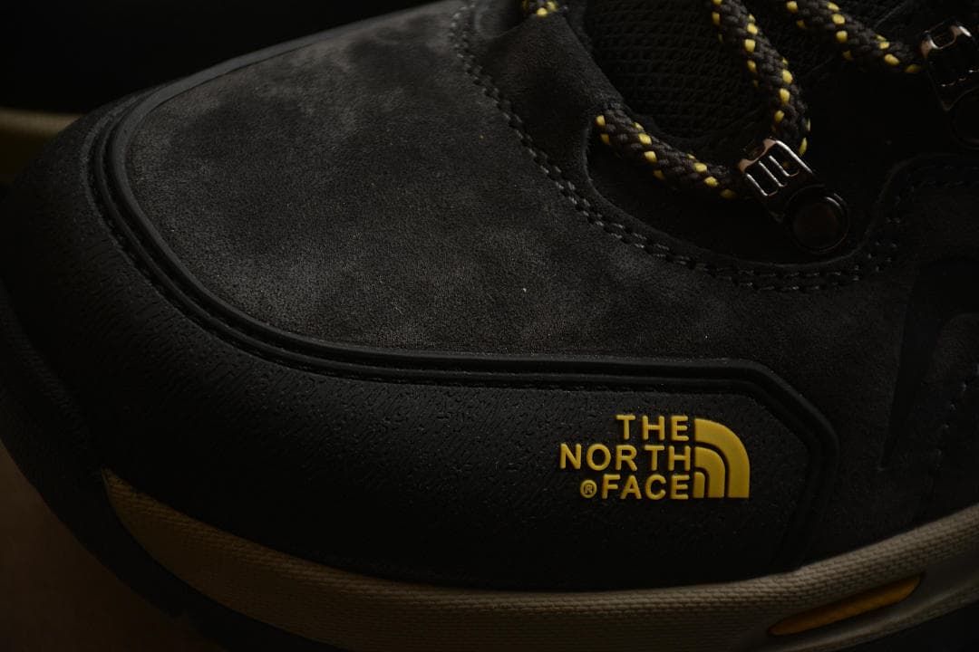 Close-up of the black toe and side panels with yellow The North Face branding.