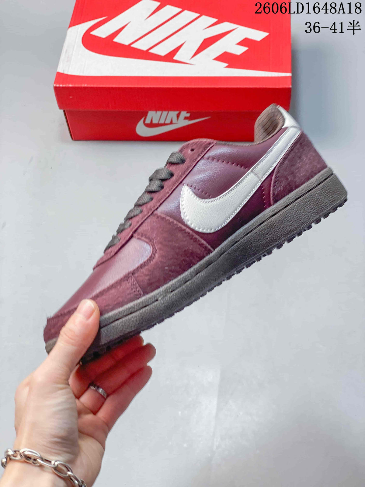 Side view of the burgundy sneaker with a contrasting Swoosh