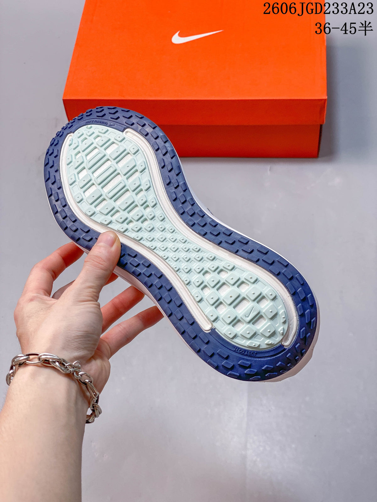 Underside of the shoe showing a light-colored central outsole area and dark blue tread around the edge.