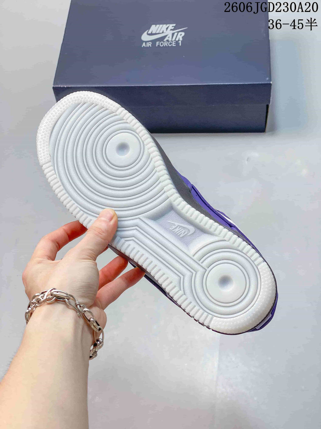 Underside of a Nike Air Force 1 sneaker showing a light-colored circular tread pattern