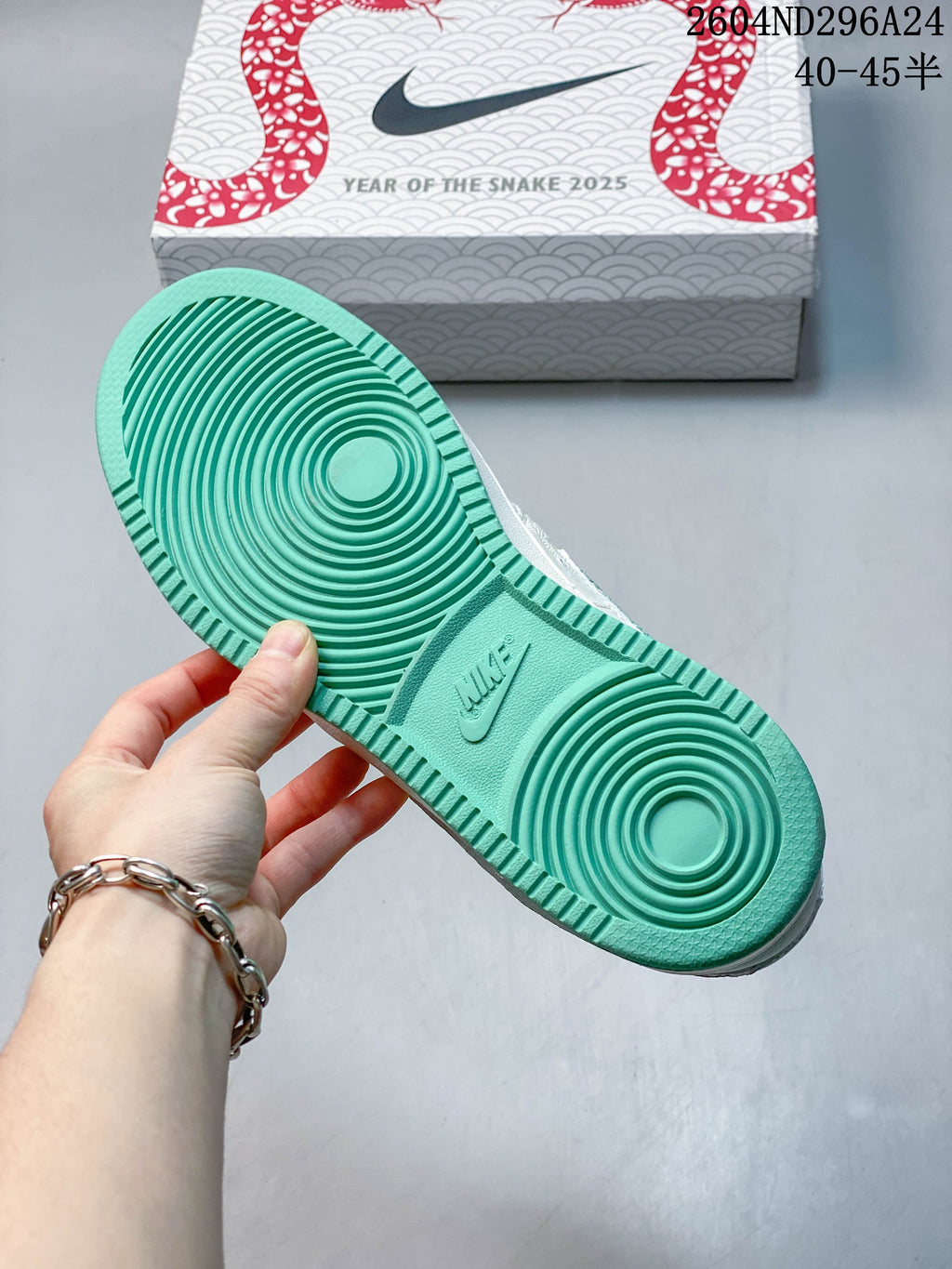 Mint-green outsole of the Nike Court Vision Low beside a Year of the Snake 2025 shoe box