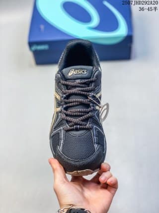 Front view of a dark navy and black ASICS Gel-Kahana 8 FL sneaker with gold-toned detailing and a lace-up upper.