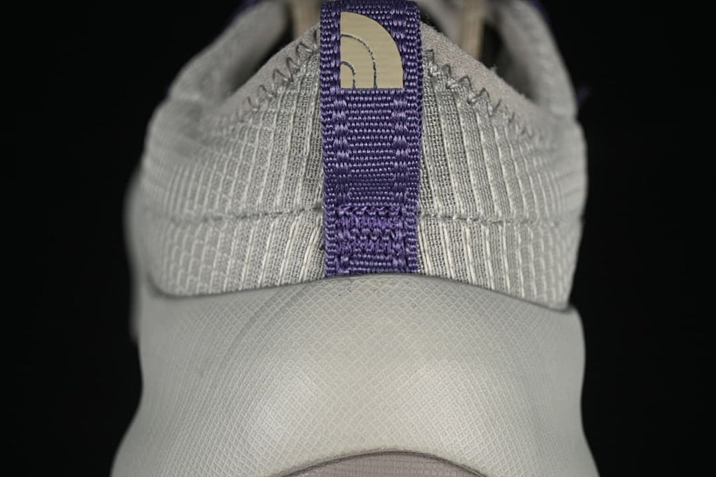 Heel view with purple pull tab and raised sole.