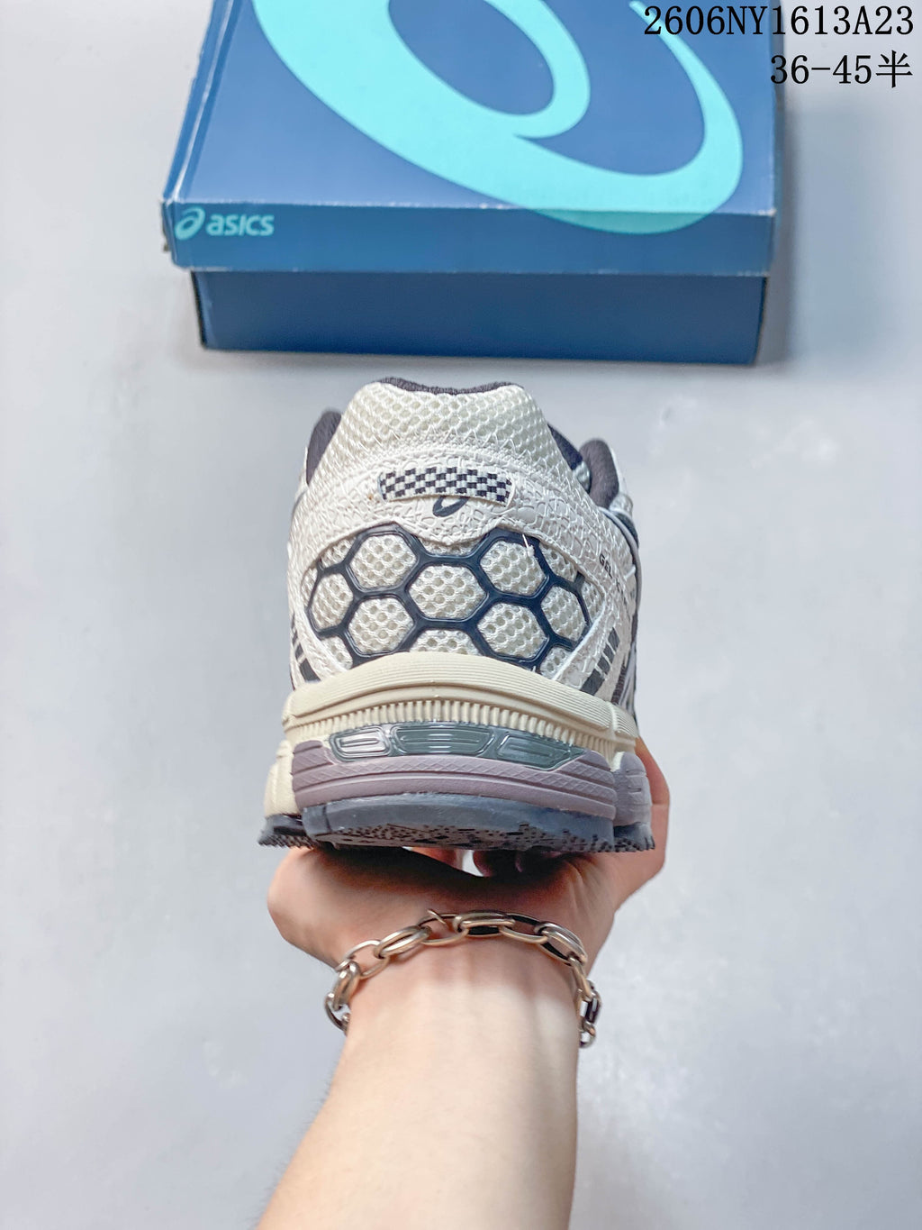Rear view showing the heel design of a cream and navy ASICS Gel-Kahana 8 shoe