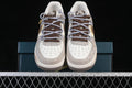 Front view of cream and taupe low-top sneakers with brown and lavender laces and illustrated accents