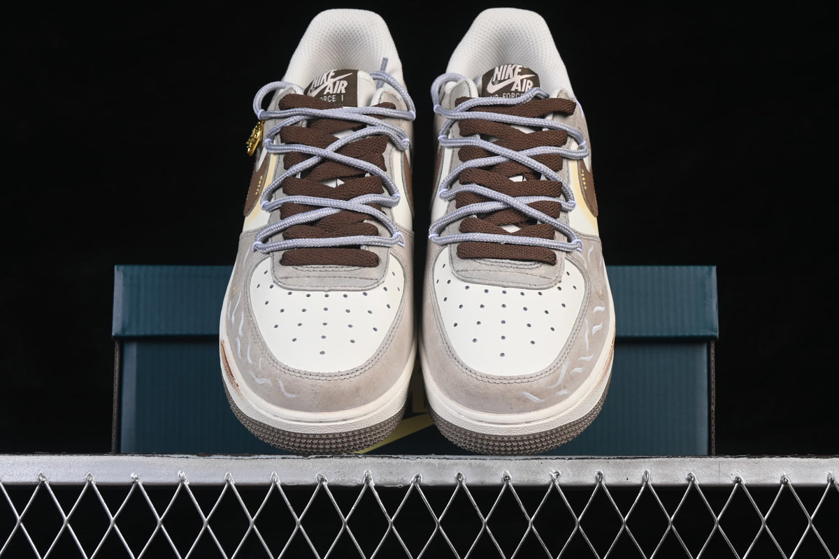 Front view of cream and taupe low-top sneakers with brown and lavender laces and illustrated accents