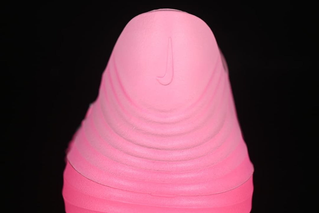 Rear view of the pink clog showing a molded heel logo and ridged shape.