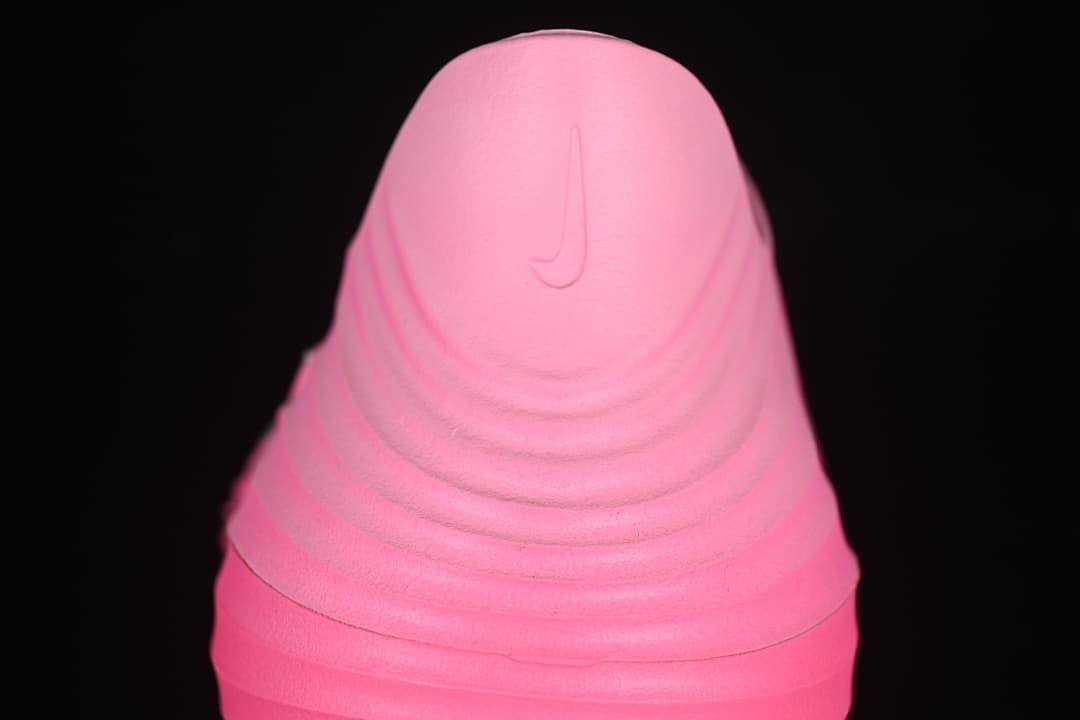 Rear view of the pink clog showing a molded heel logo and ridged shape.