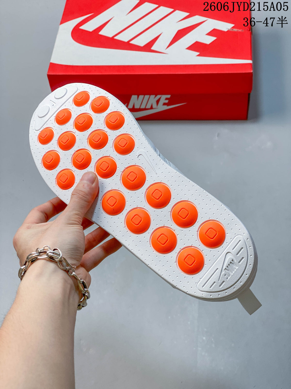 Outsole view showing white tread with orange circular accents