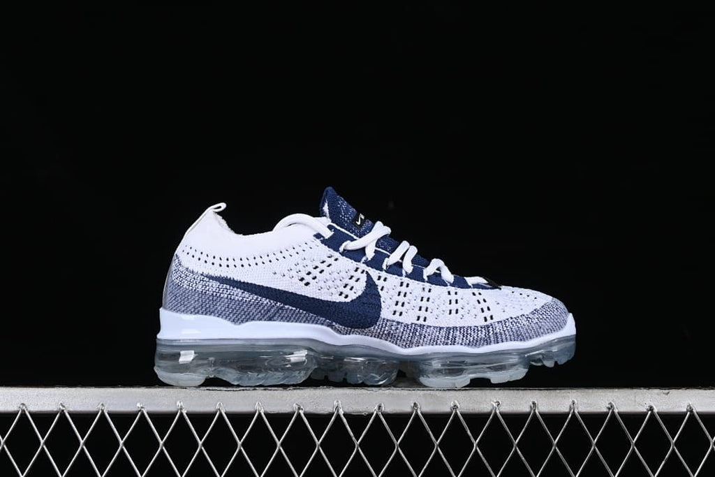 Side profile of the white and navy Nike Air VaporMax 2023 Flyknit sneaker