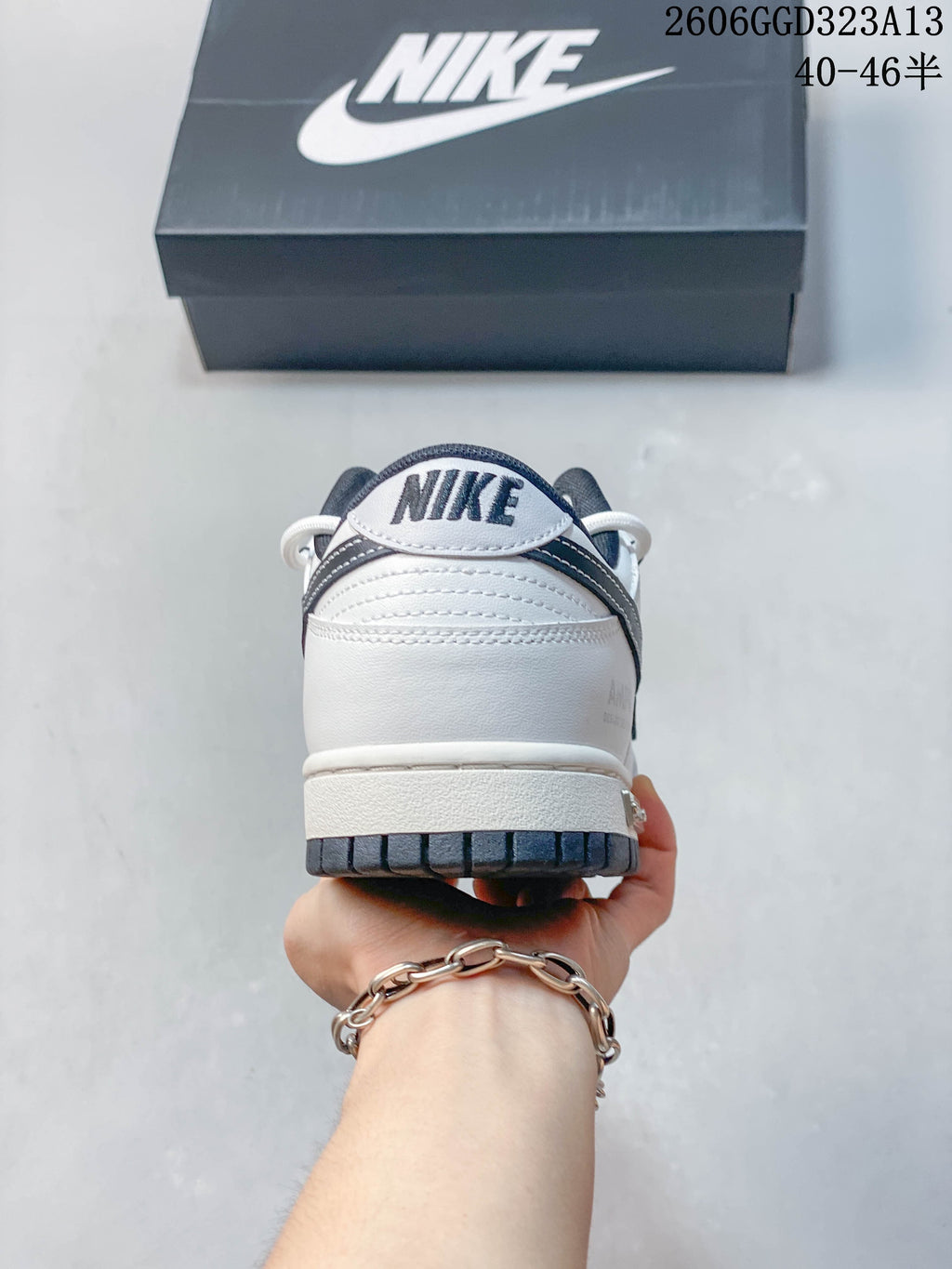 Rear view showing the heel panel and dark outsole of a white and navy sneaker