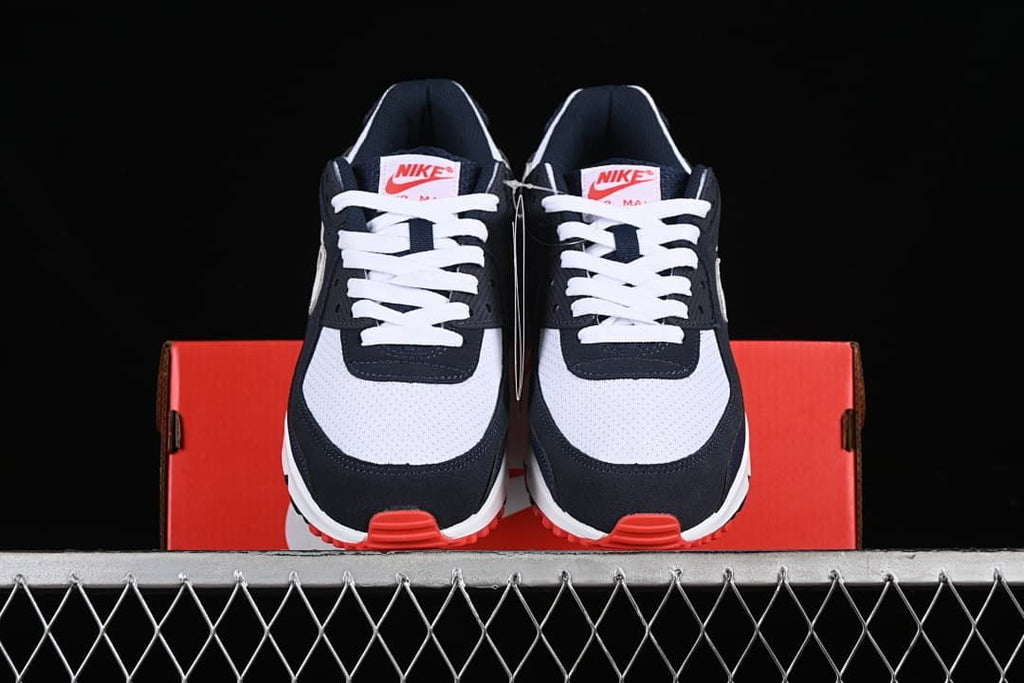 Front view of the sneakers displayed on a red shoe box