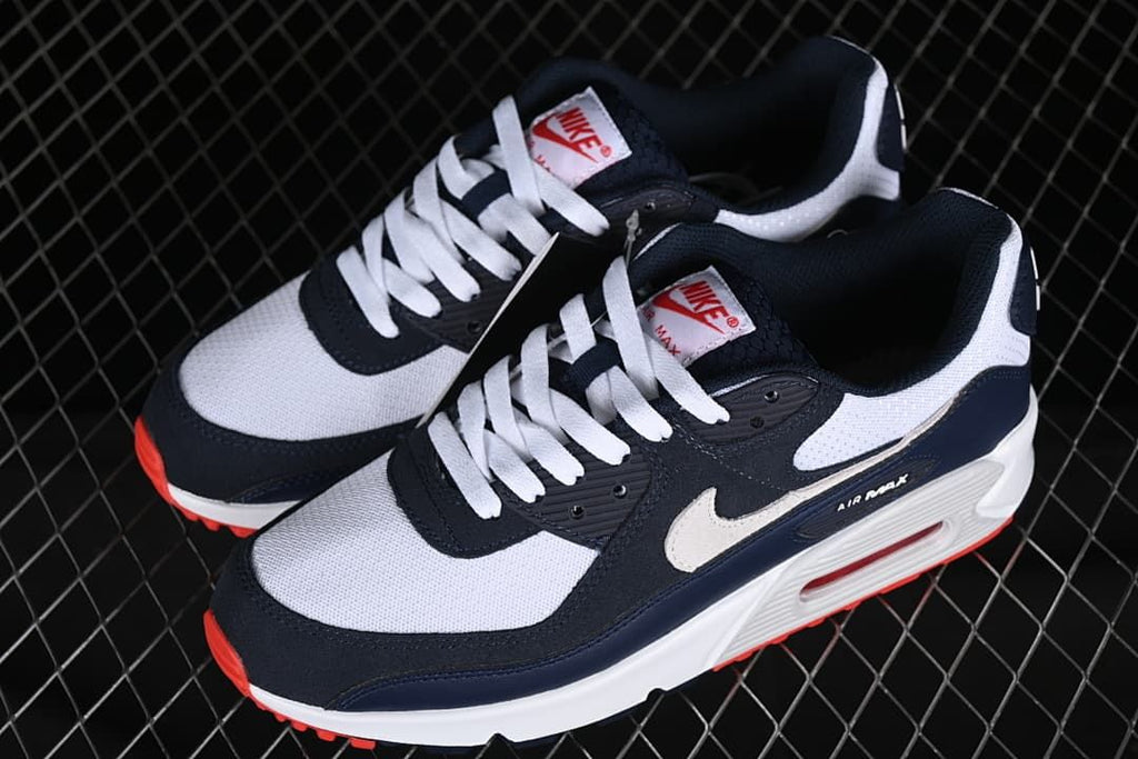 Pair of navy, white, and red Nike Air Max 90 sneakers