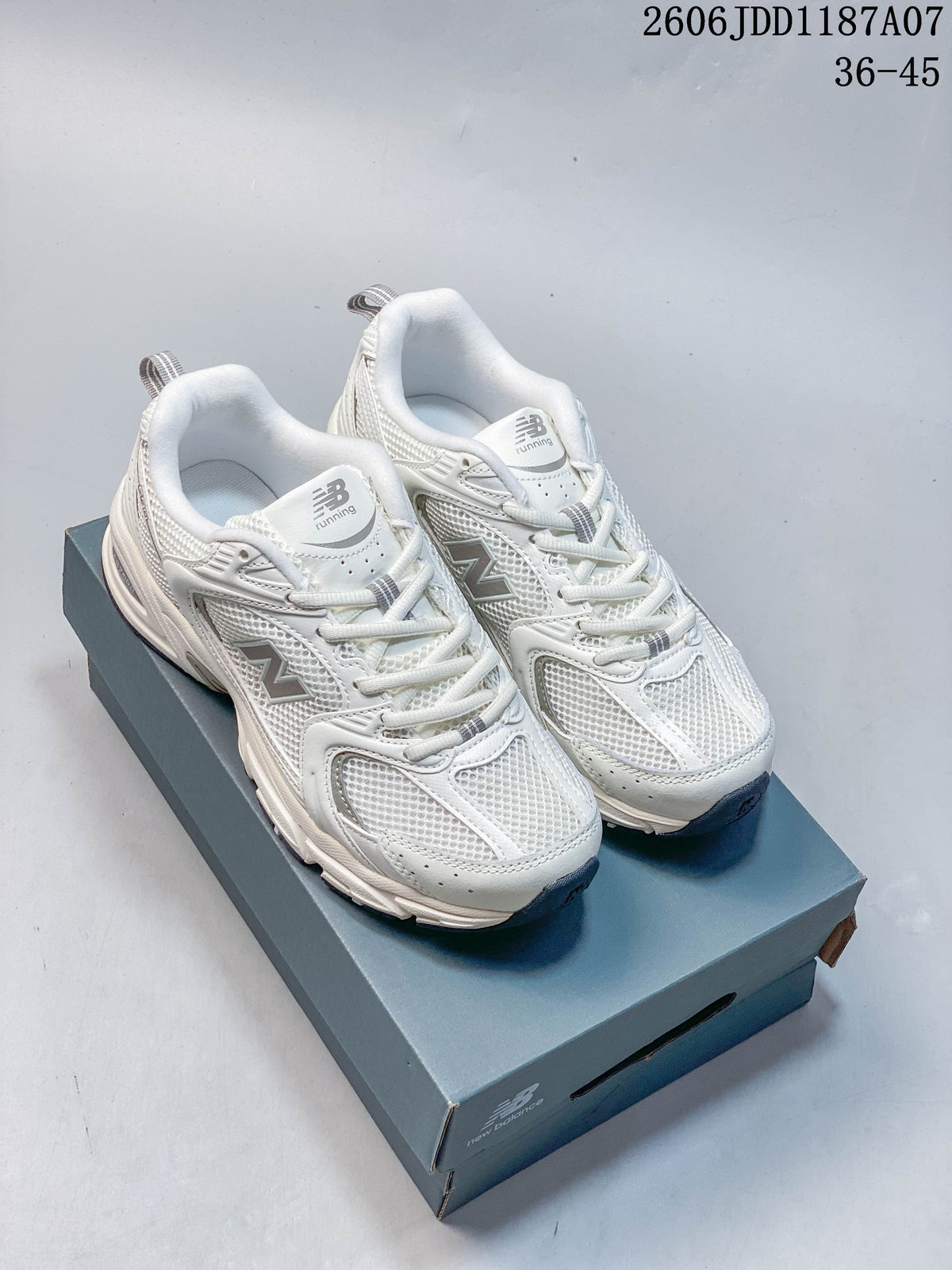 White and silver-gray New Balance 530 sneakers shown from the front and three-quarter angles on a shoe box.