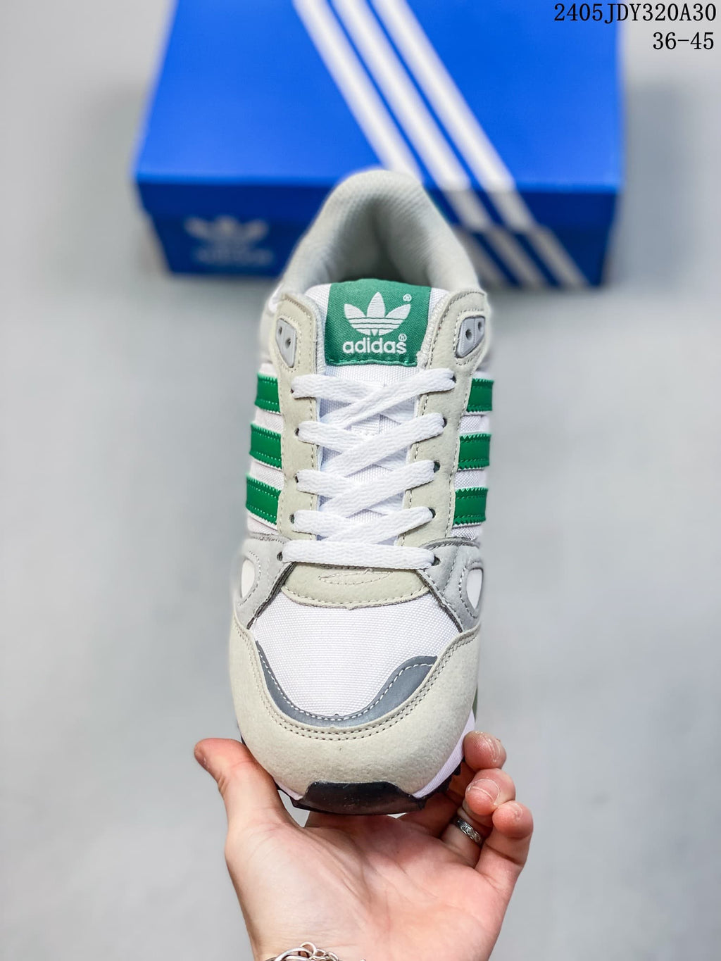 Front view of the ZX 750 sneaker with white laces and green tongue branding.
