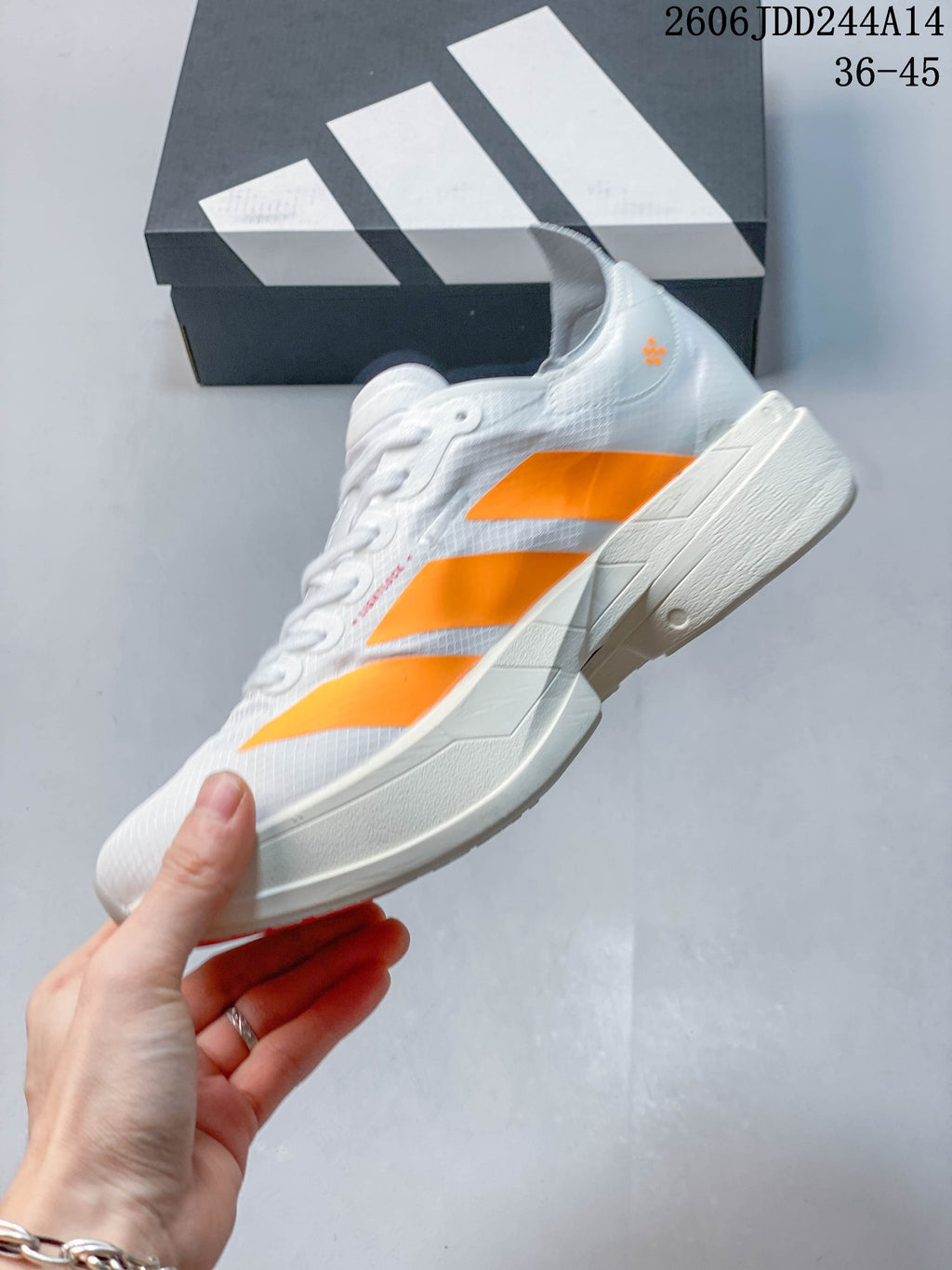 Side view of the white running shoe with orange stripes, red accents and a sculpted midsole; image overlay states EU sizes 36–45.