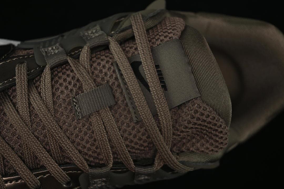 Close-up of the mesh-like upper and brown lace-up fastening