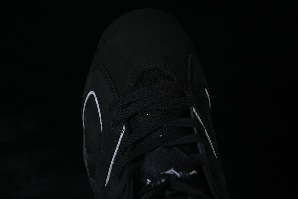 Top-down close-up of the black laces and perforated sneaker panels.