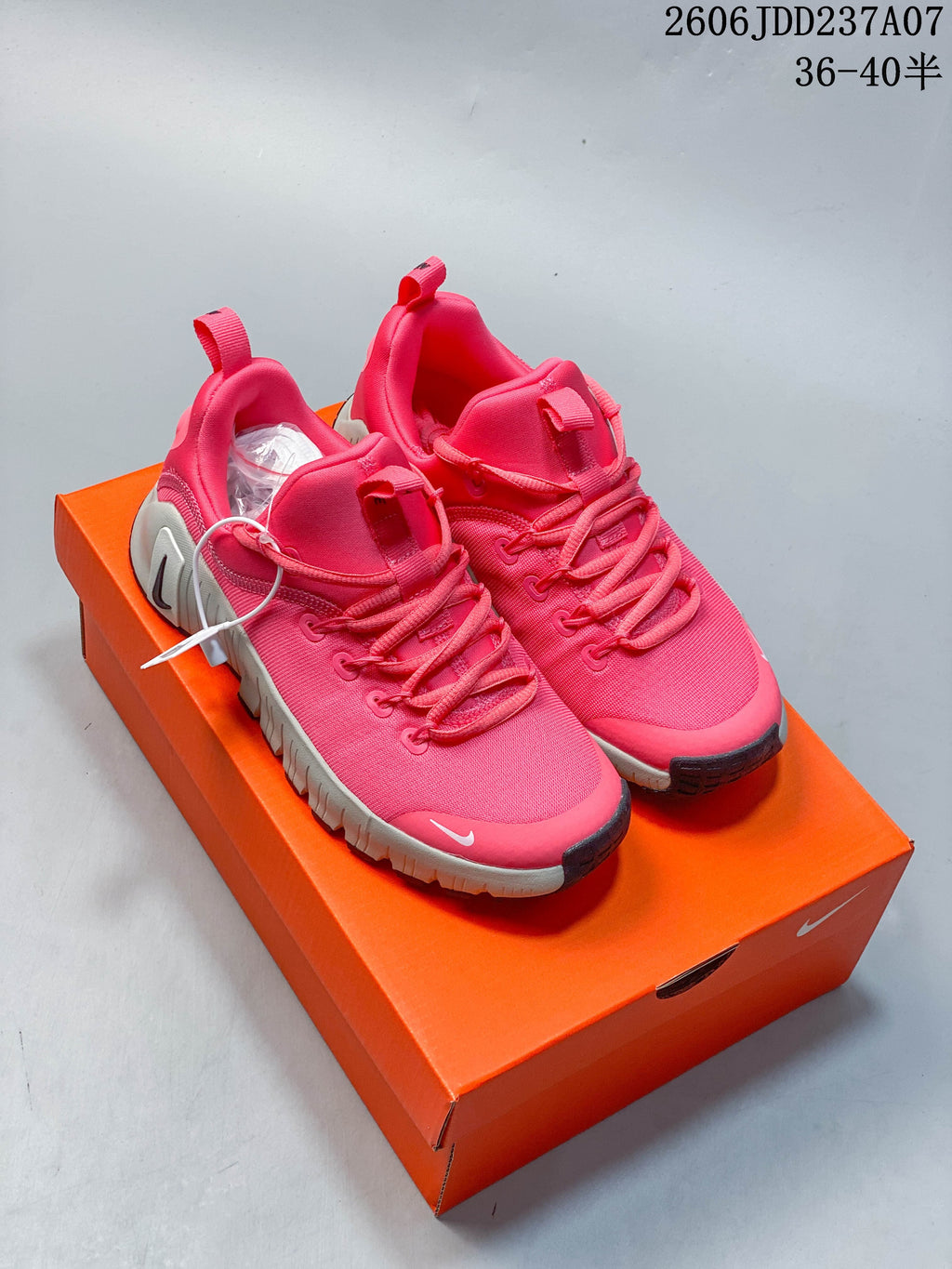 Pair of bright pink Nike Free Metcon 6 shoes on an orange shoe box.
