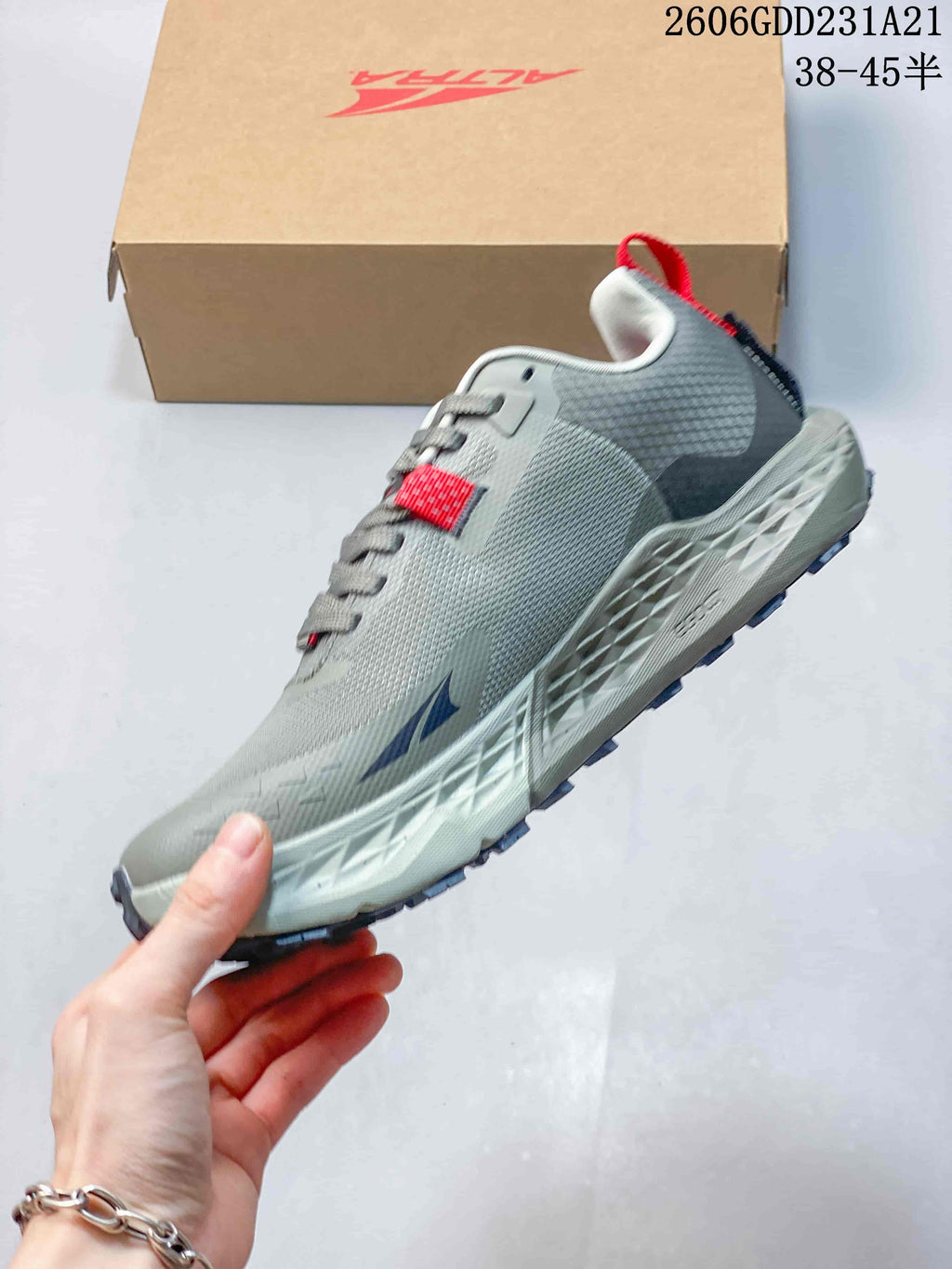 Side view of the gray low-top trail running shoe with navy details