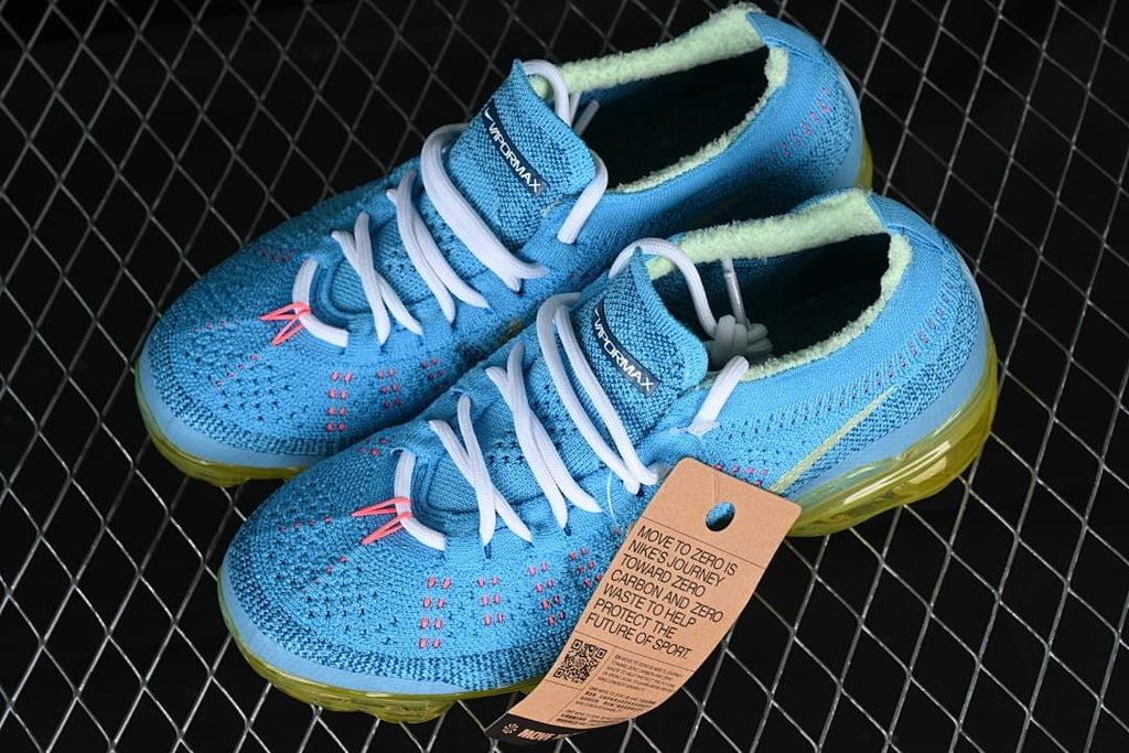 Pair of blue VaporMax-style sneakers with white laces and translucent yellow soles.