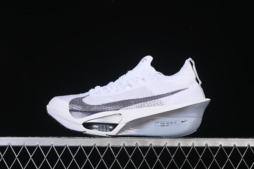 Side view of a white Nike racing shoe with a large grey Swoosh and sculpted sole
